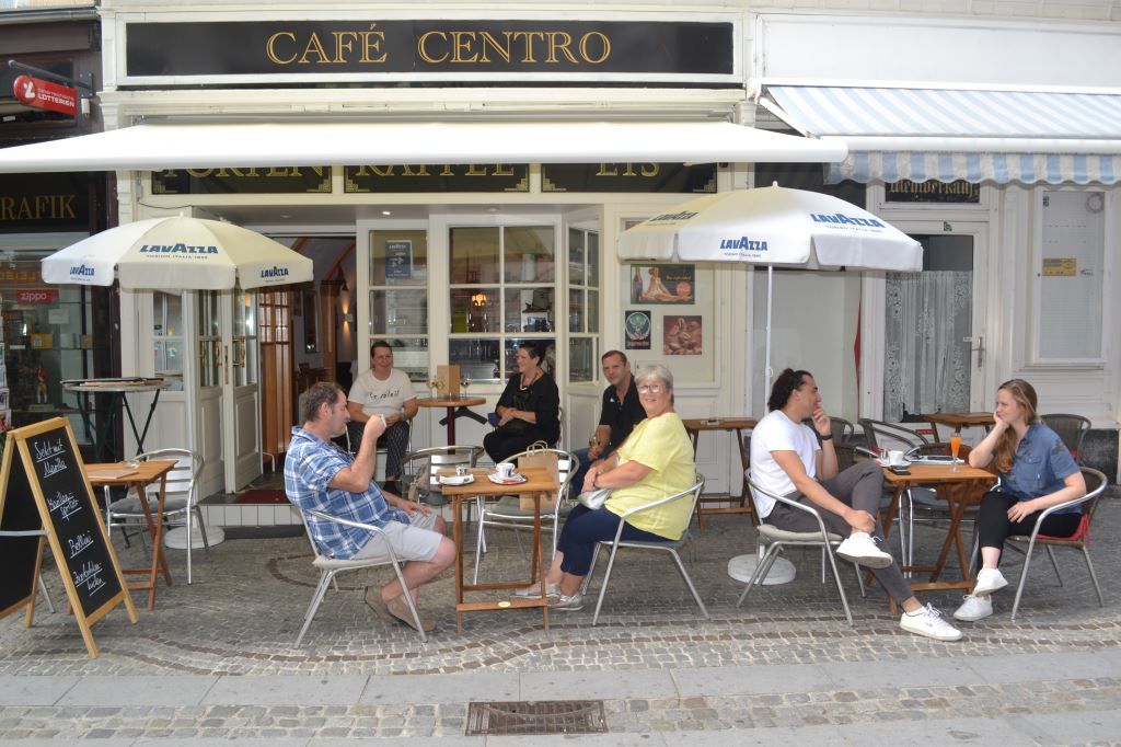 Lidé sedí před kavárnou Café Centro.