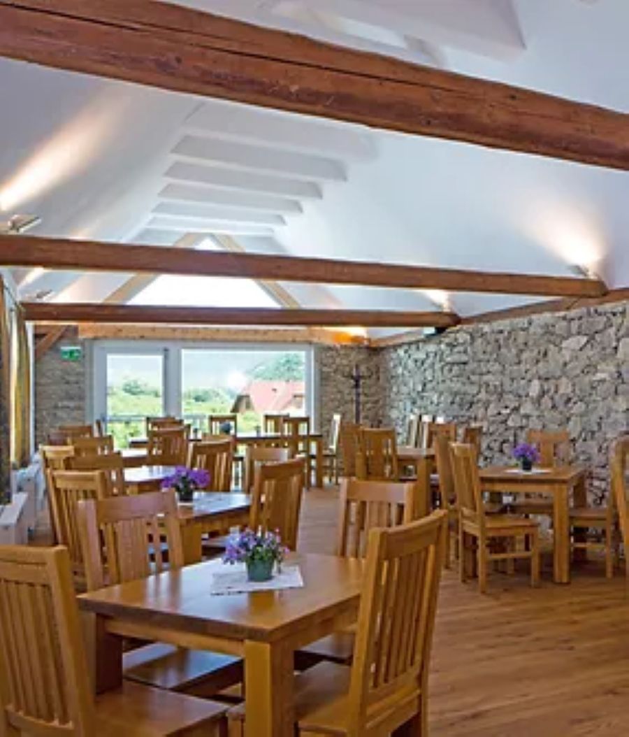 Jídelna s dřevěnými stoly a židlemi