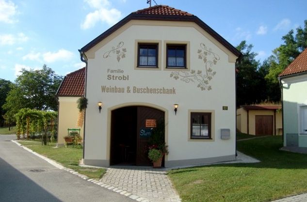 Malá budova s nápisem "Familie Strobl Weinbau & vinné šenky".