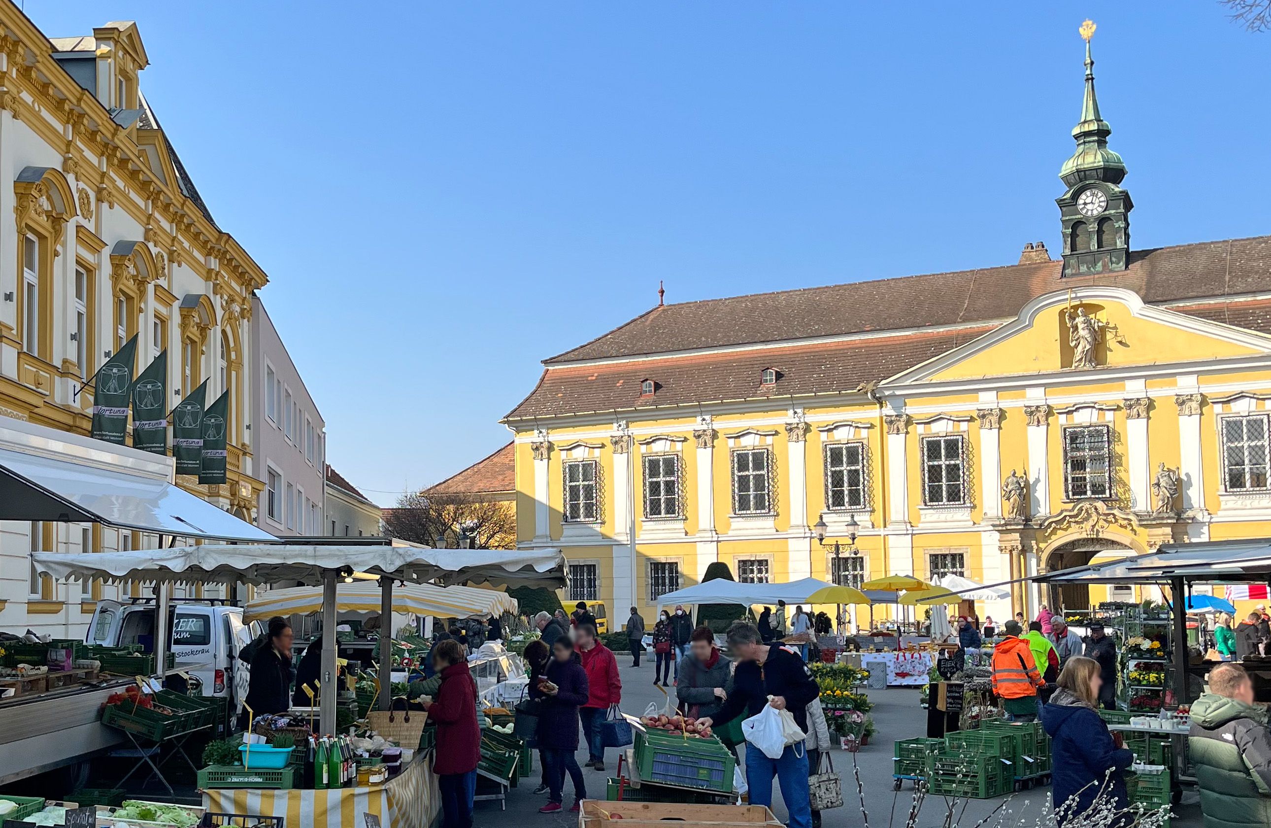 Týdenní trh ve Stockerau s historickými budovami v pozadí.