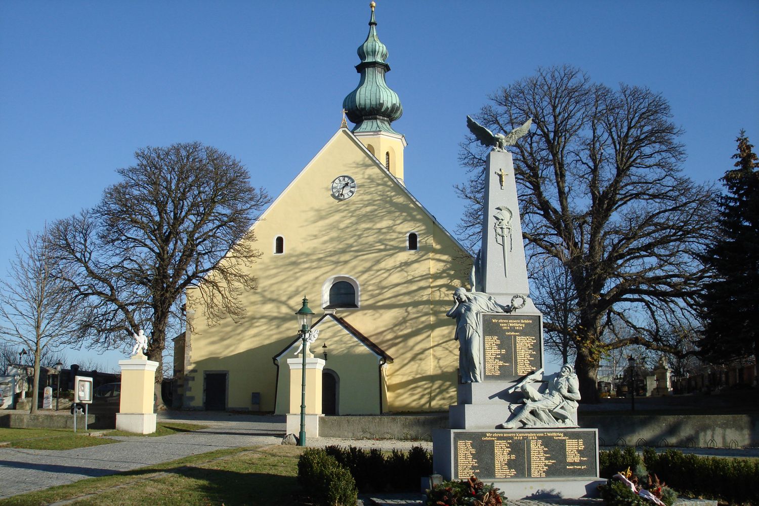 Farní kostel svatého Hippolyta s válečným památníkem v popředí.