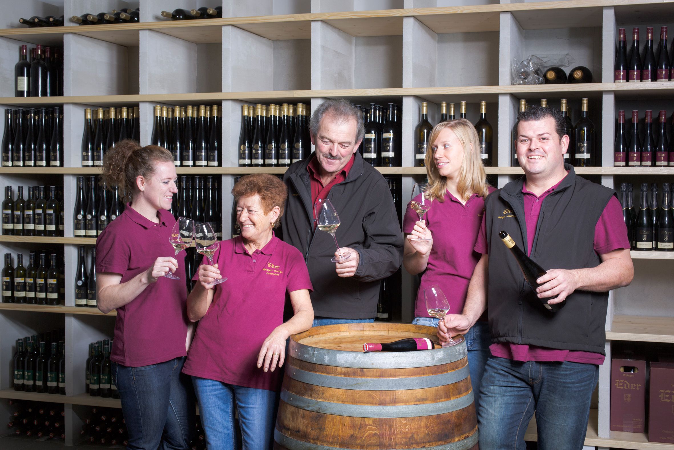 Pět lidí ve vinném sklípku cinká skleničkami.