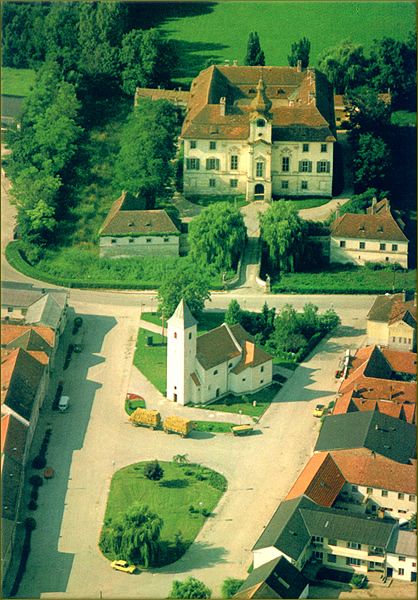 Letecký pohled na vesnici s kostelem a zámkem v Seibersdorfu.