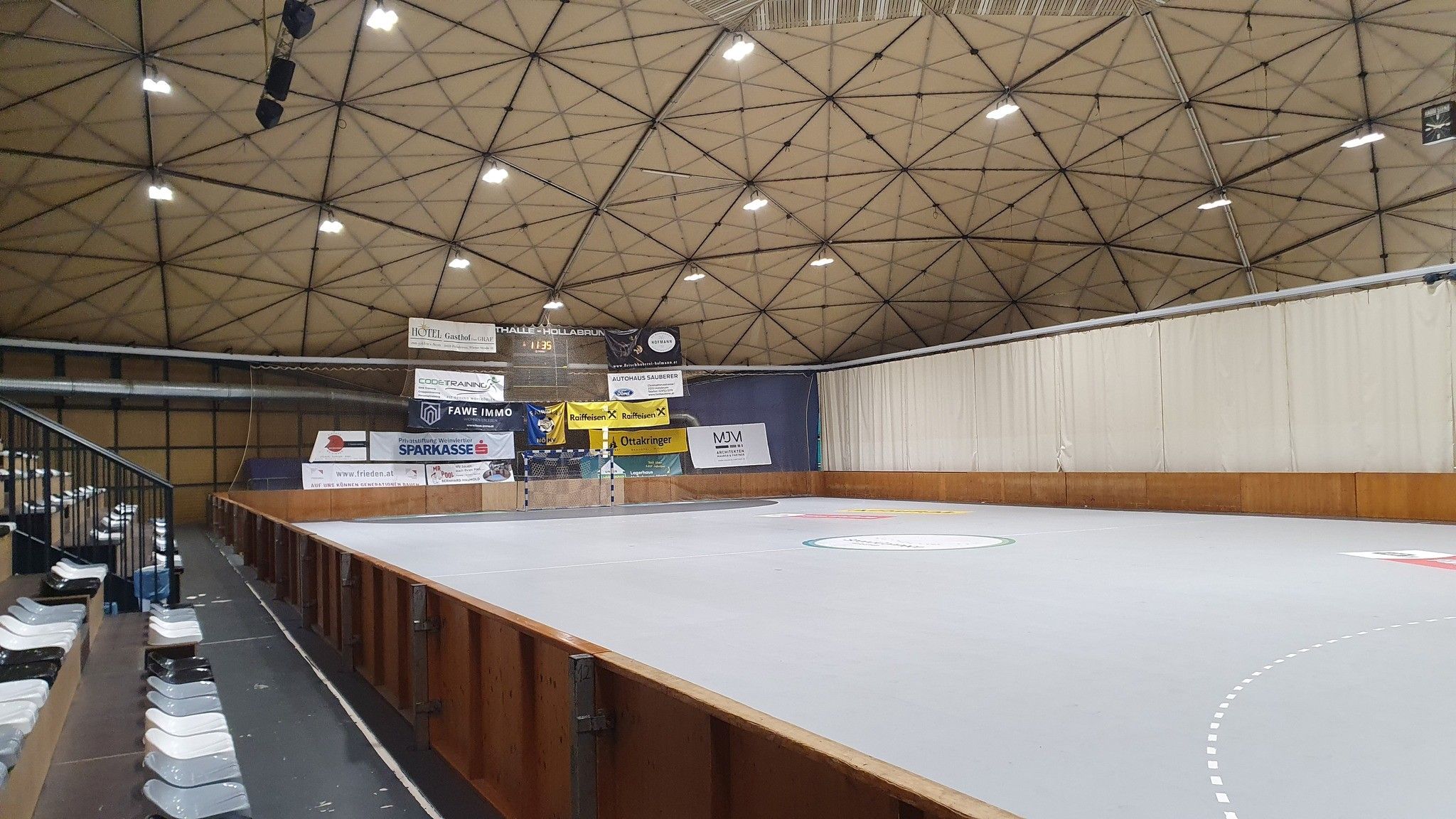 Pohled do interiéru sportovní haly Hollabrunn s prázdnými tribunami a hrací plochou.