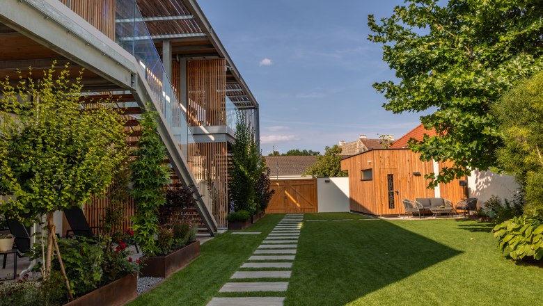 Moderní apartmánový komplex se zahradou a dřevěným obložením.