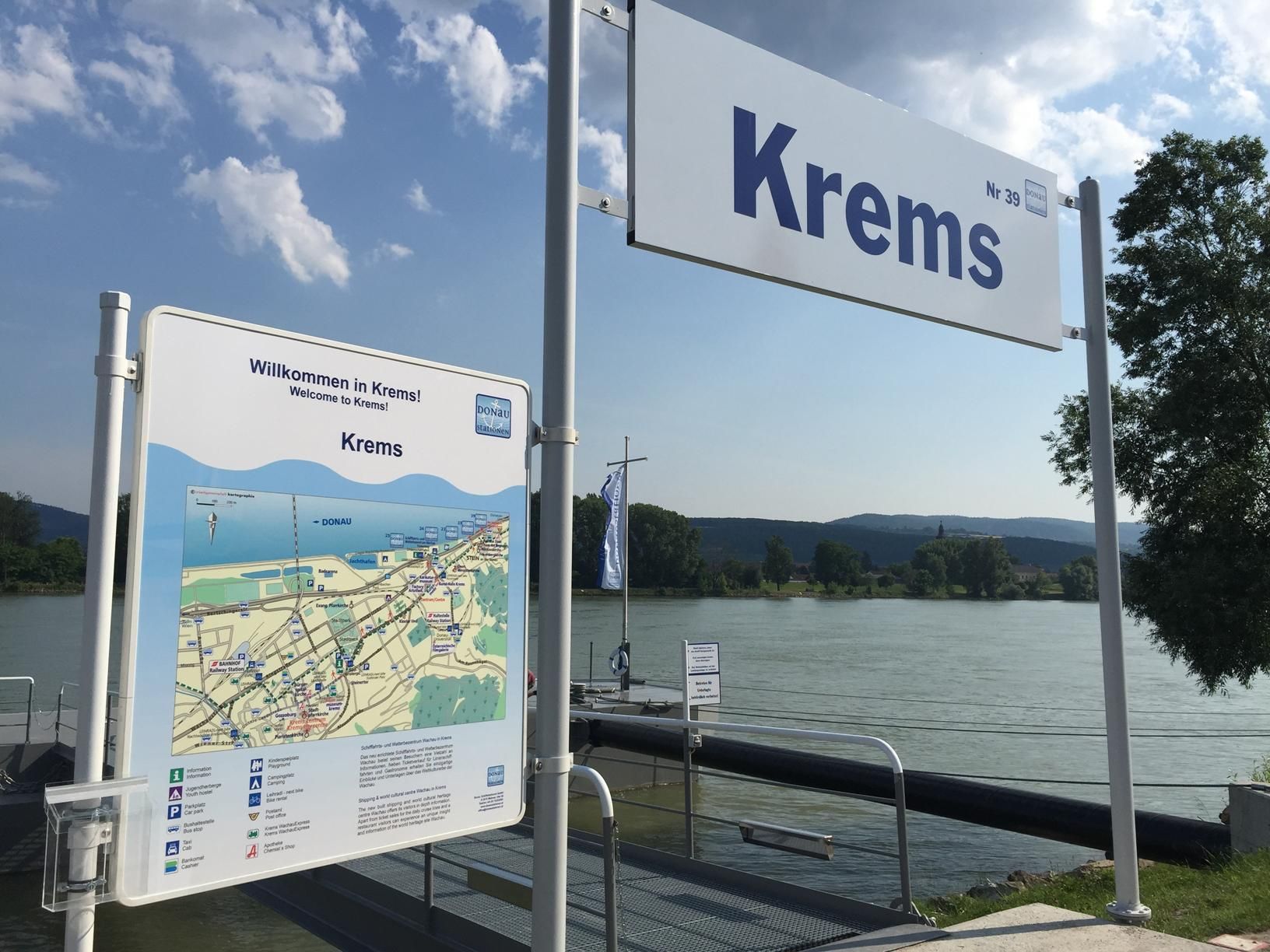 Molo v Kremsu s uvítací cedulí a Mapou, v pozadí řeka.