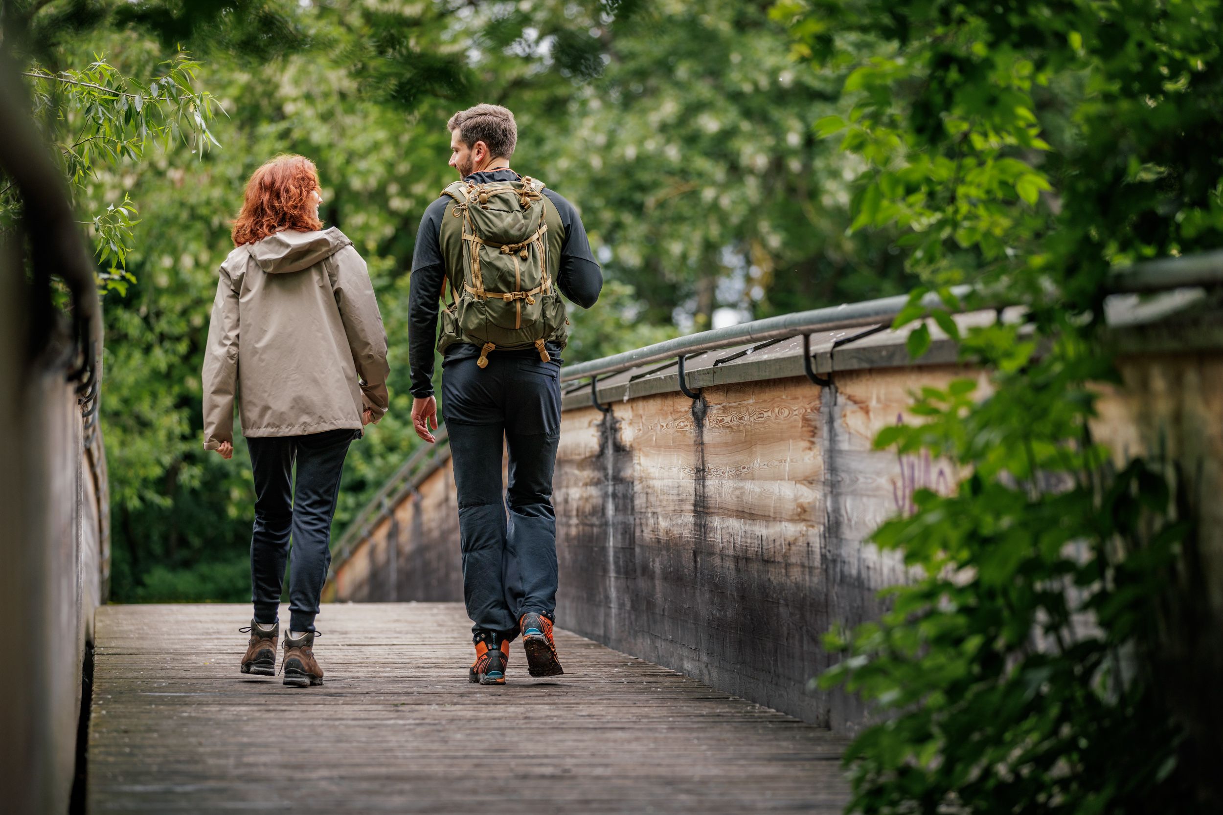 Dva turisté na dřevěném mostě v lese