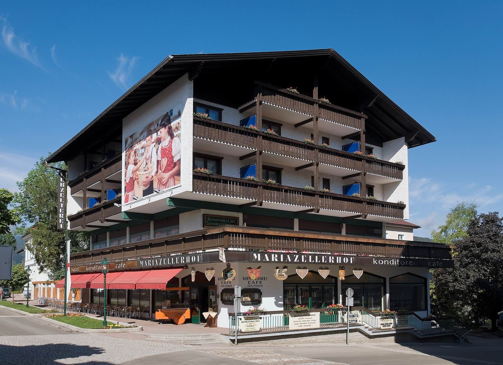 Pohled na exteriér hotelu Pirker Mariazellerhof s balkony a kavárnou.