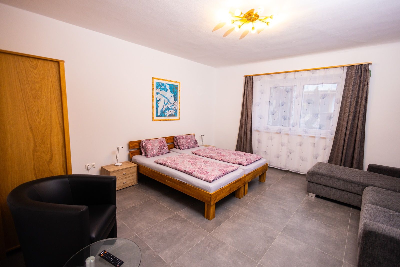 Ložnice s manželskou postelí, pohovkou a křeslem.