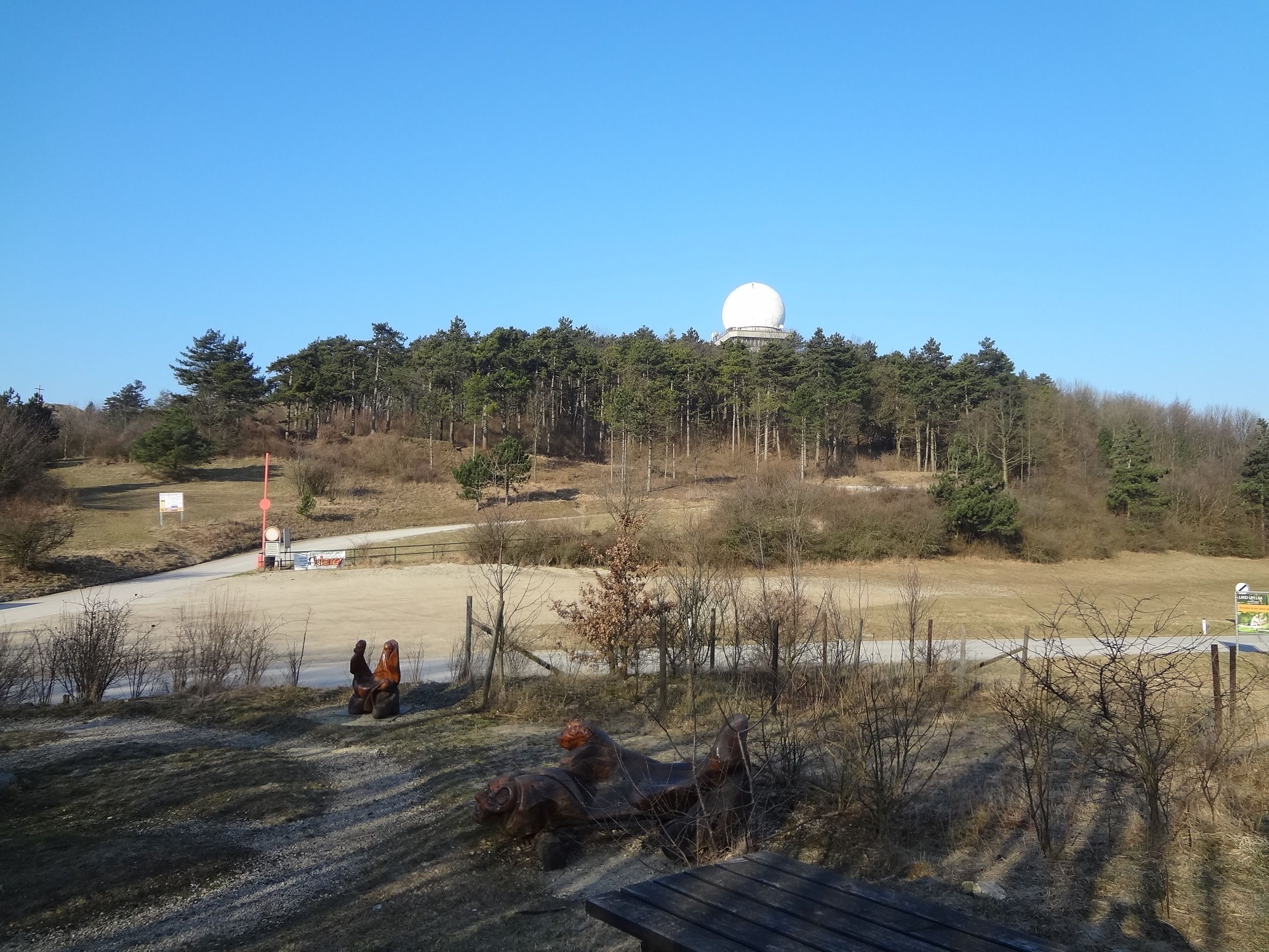 Krajina s kopci, lesem a radarovou kopulí na Buschbergu.