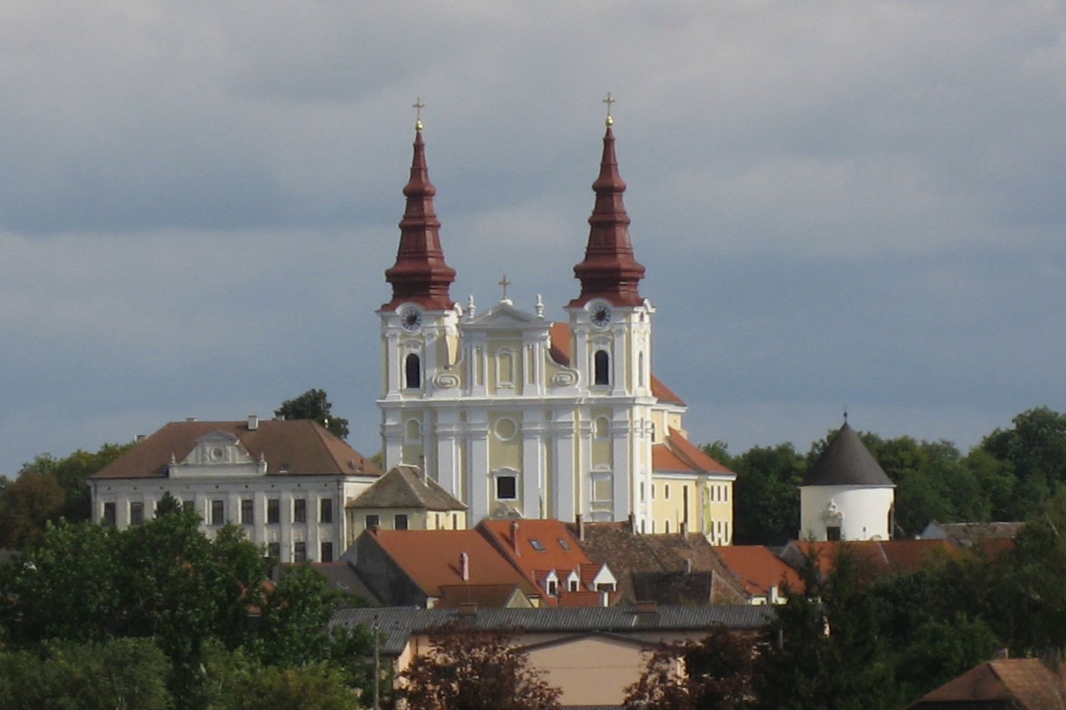 Barokní kostel se dvěma věžemi a okolními budovami.