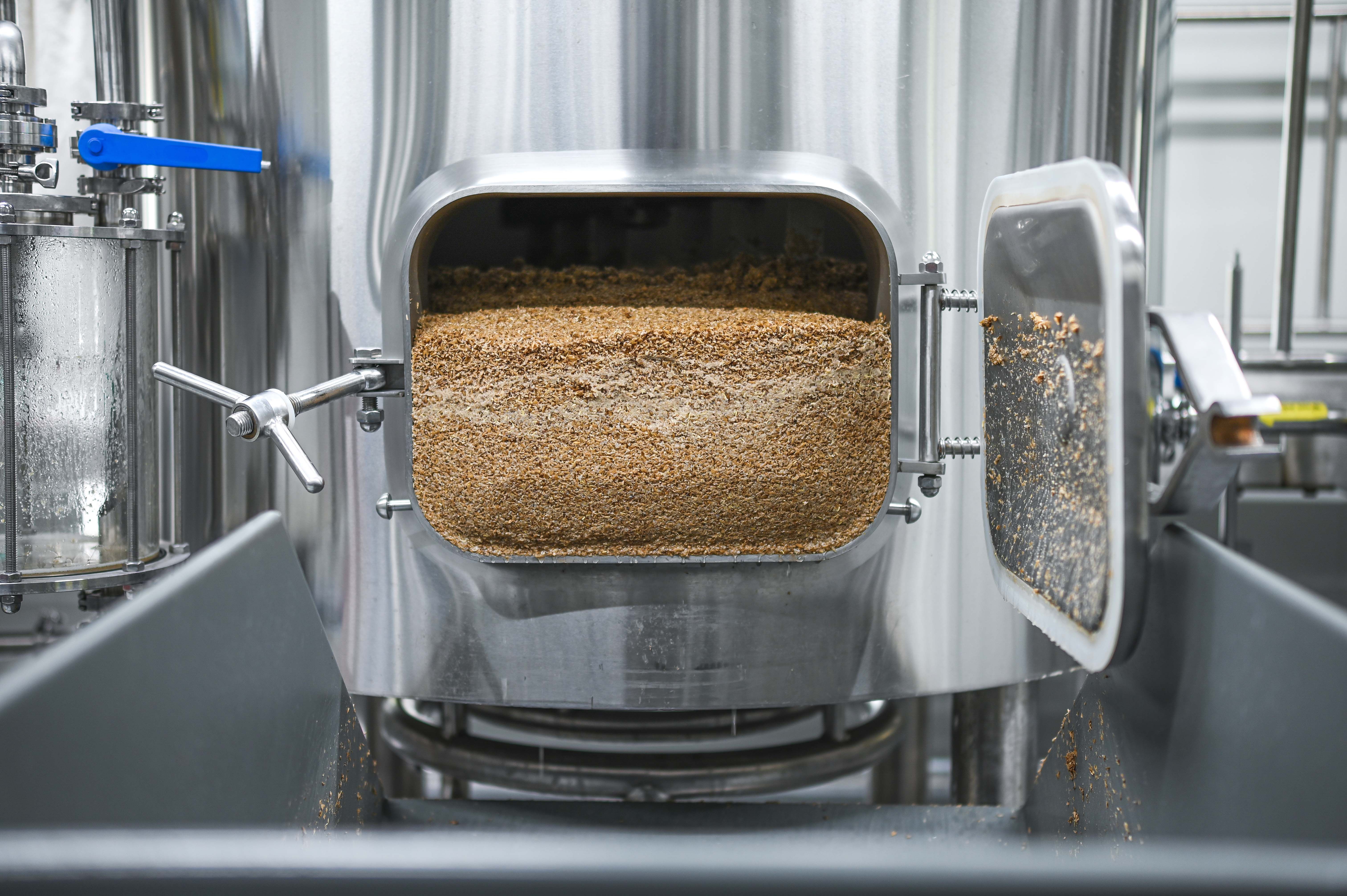 Otevřený varný kotel se zbytky obilí v pivovaru.