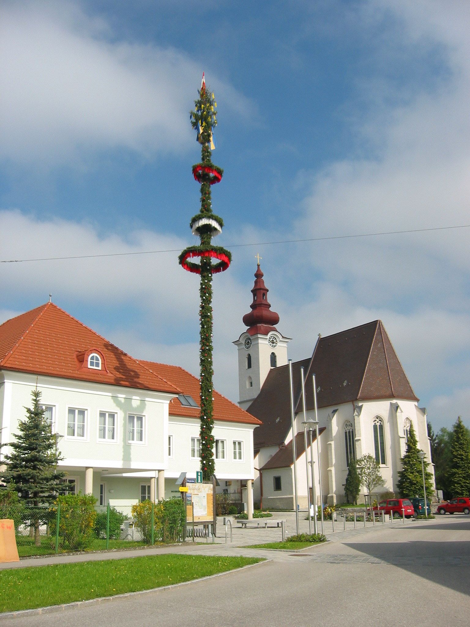 Kostel s cibulovou kopulí a májkou v obci St. Pantaleon-Erla.