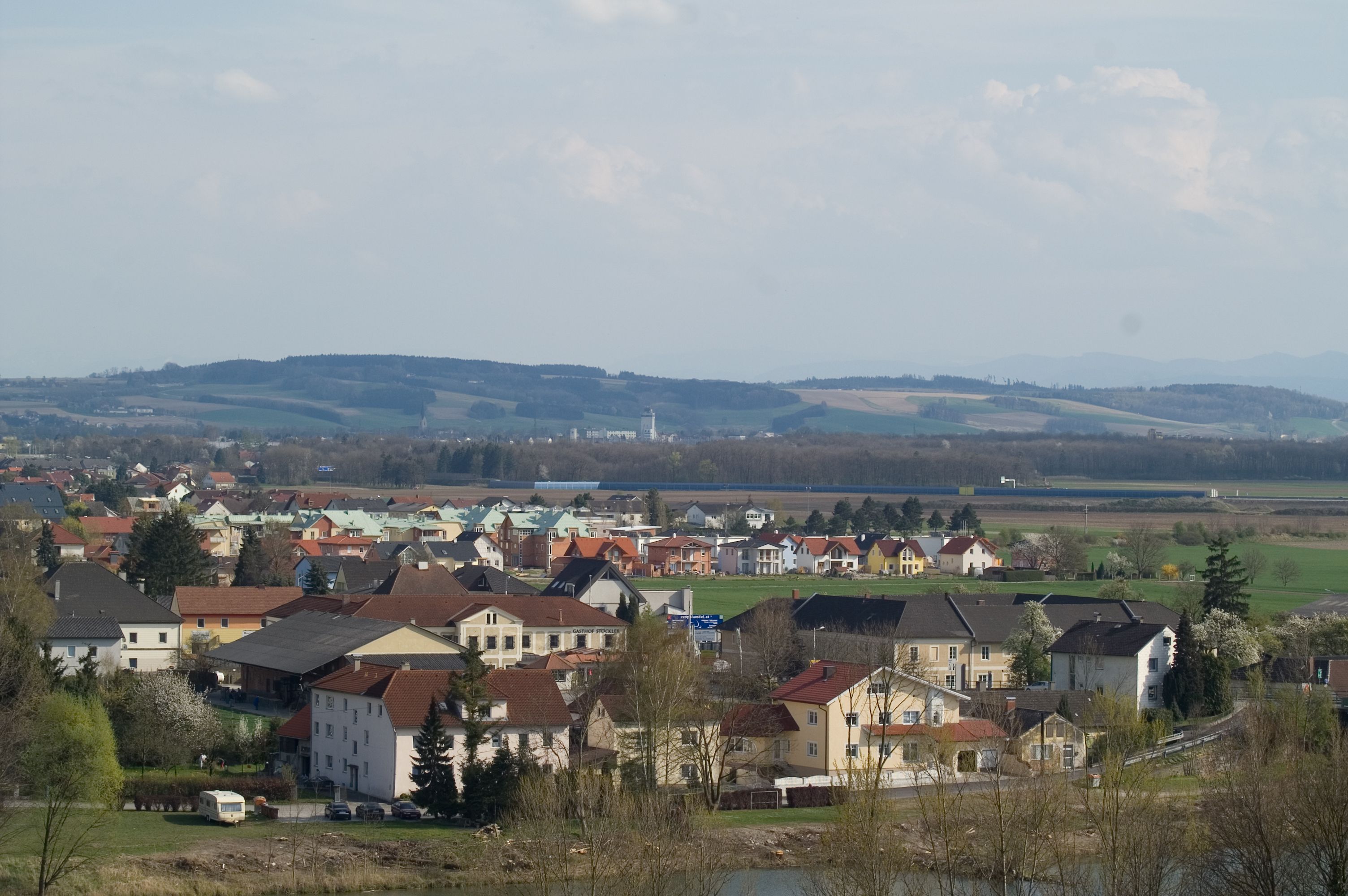 Panoramatický pohled na Ennsdorf s domy a kopci v pozadí.