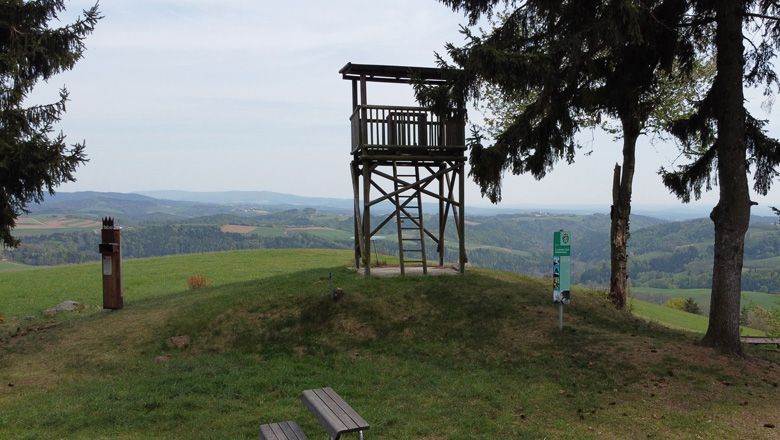 Vyhlídková plošina na kopci s výhledem na kopcovitou krajinu.