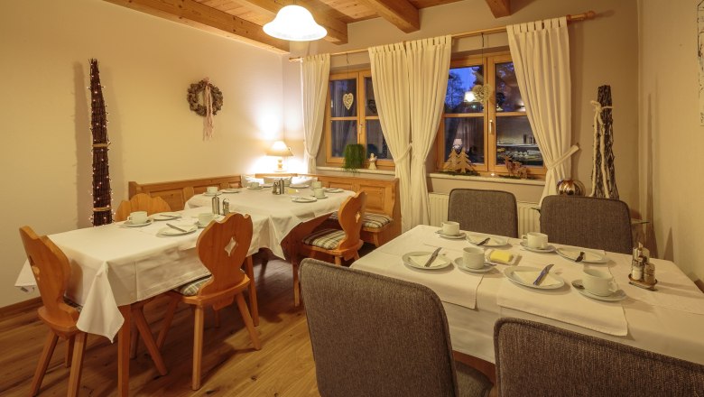 &Uacute;tuln&aacute; sn&iacute;daňov&aacute; m&iacute;stnost s prostřen&yacute;mi stoly, dřevěn&yacute;m n&aacute;bytkem a dekoracemi.