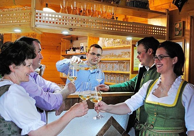 Lidé si v útulném baru cinknou skleničkami s nápoji.