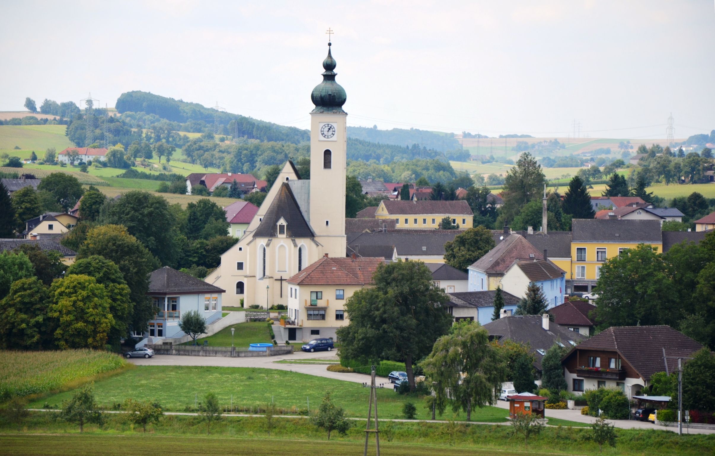 Pohled na tržní město Ruprechtshofen s kostelem a okolními domy ve venkovské krajině.