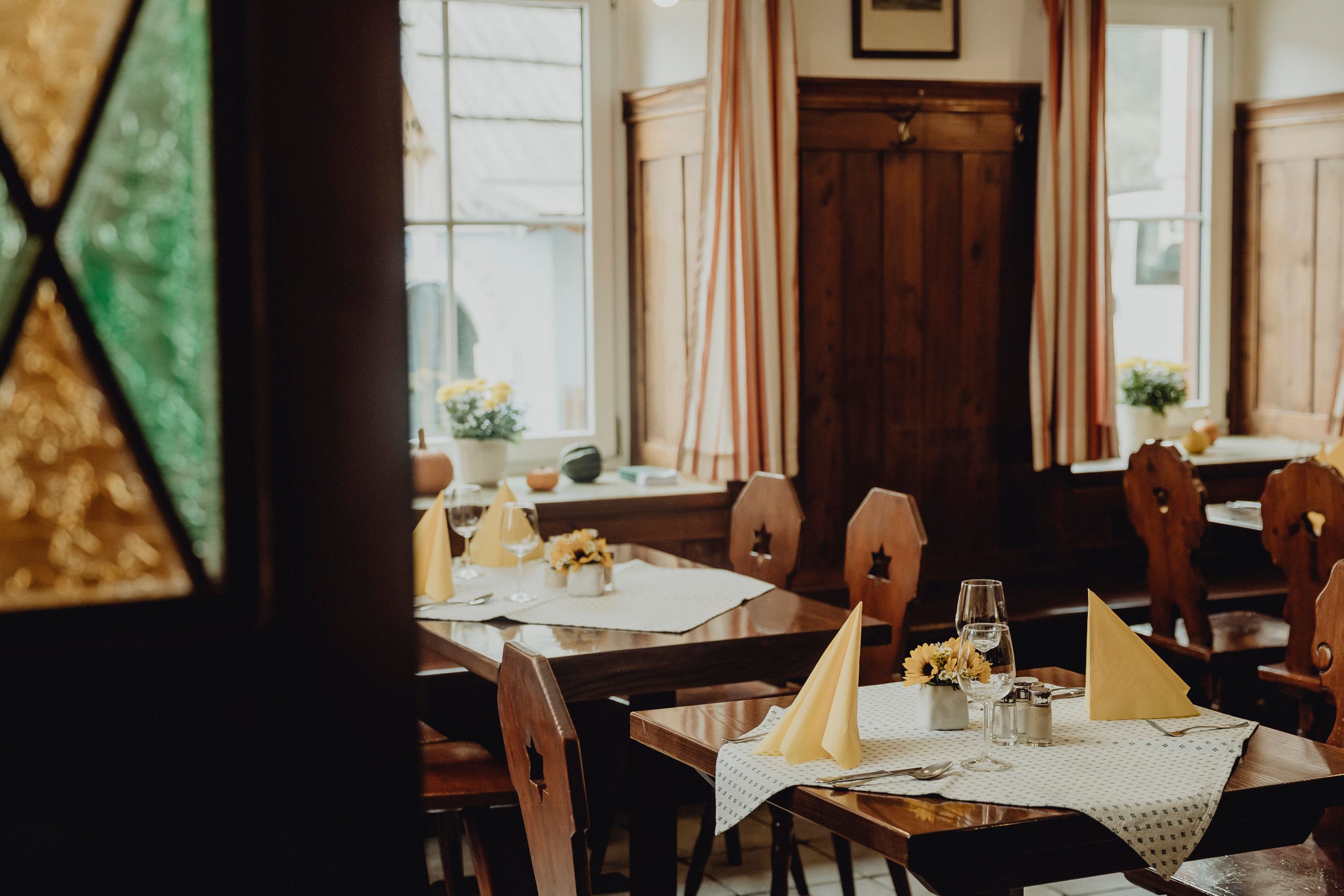 Útulná restaurace s dřevěným nábytkem a prostřenými stoly.
