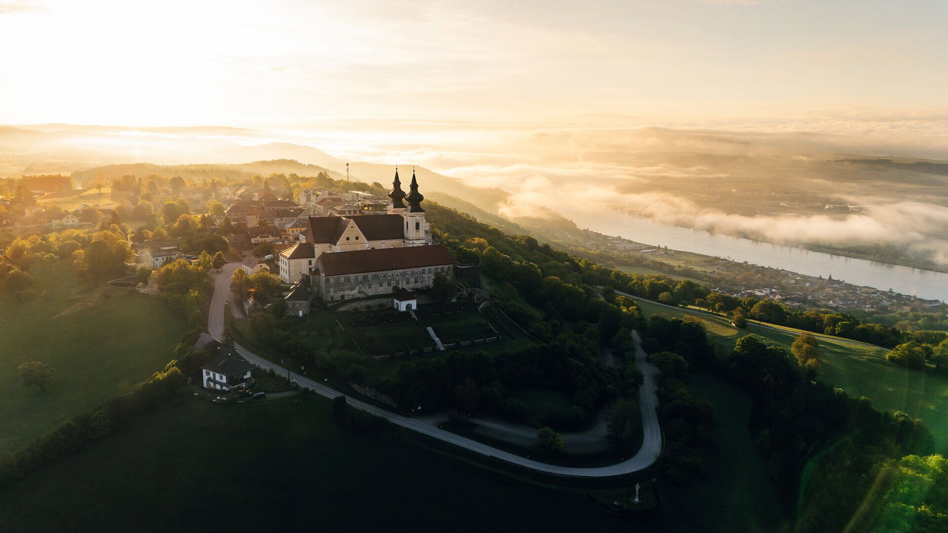 Majestátní baziliku obklopují kopce a v dálce se třpytí Dunaj. Úchvatný východ slunce zalévá krajinu teplým světlem a vybízí turisty, aby si vychutnali krásu přírody. Zde, kde se nebe líbá se zemí, se rozprostírá skutečný „ráj výhledů“.