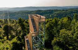 Die majestätische Aussicht von der Aussichtsplattform bietet einen atemberaubenden Blick über die sanften Hügel und dichten Wälder. Hier, wo die Natur in voller Blüte steht, spürt man die frische Bergluft und die Ruhe der Umgebung. Ein perfekter Ort, um die Schönheit des Frühlings in den Bergen zu genießen.