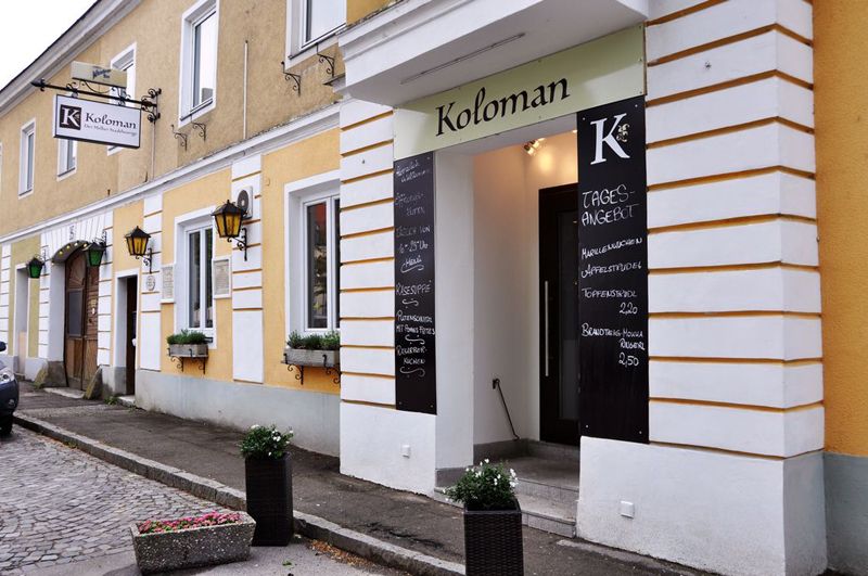 Vstup do restaurace Koloman v Melku s denními nabídkami na tabulích.