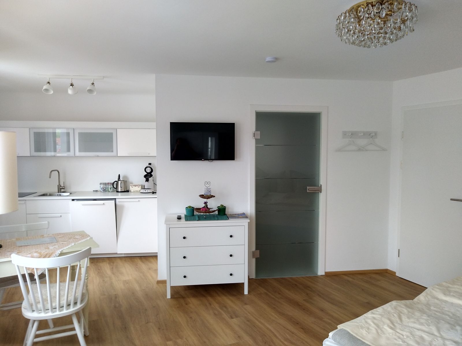 Moderní byt s kuchyní, jídelním stolem a TV.