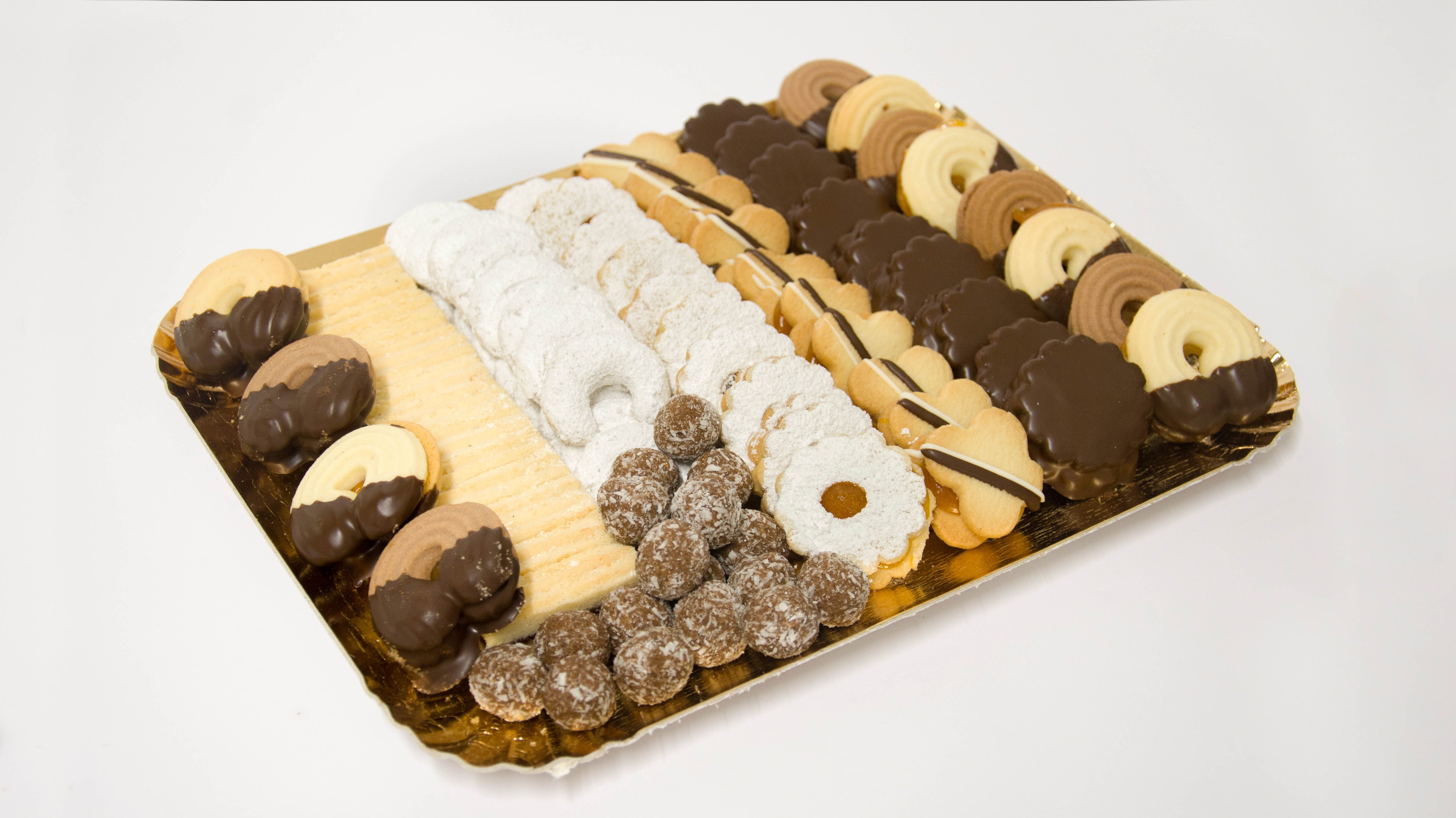 Různé druhy čajových sušenek na zlatém podnosu.