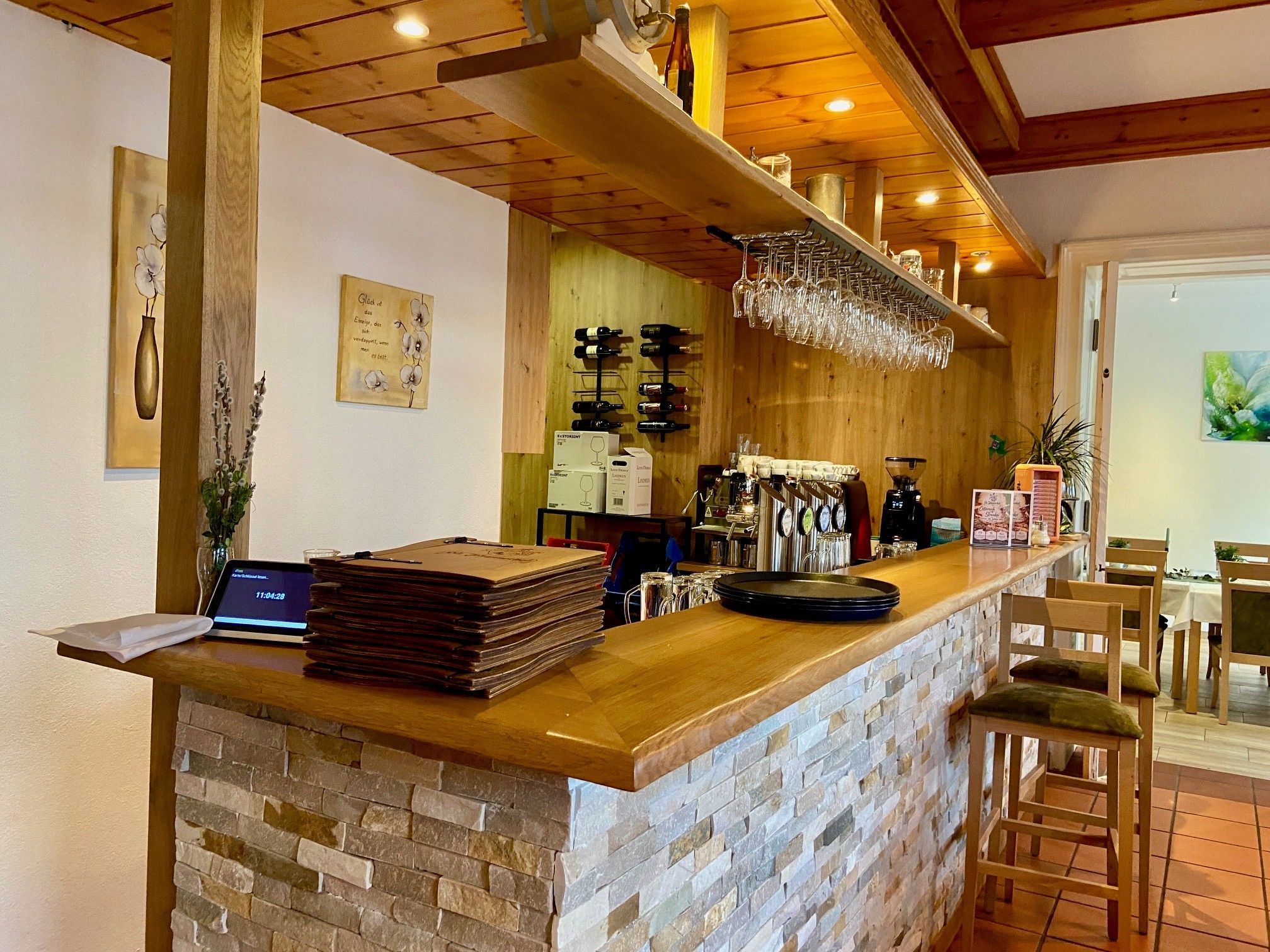 Útulný bar s dřevěným pultem a stoličkami v hotelu Sankt Johannerhof.