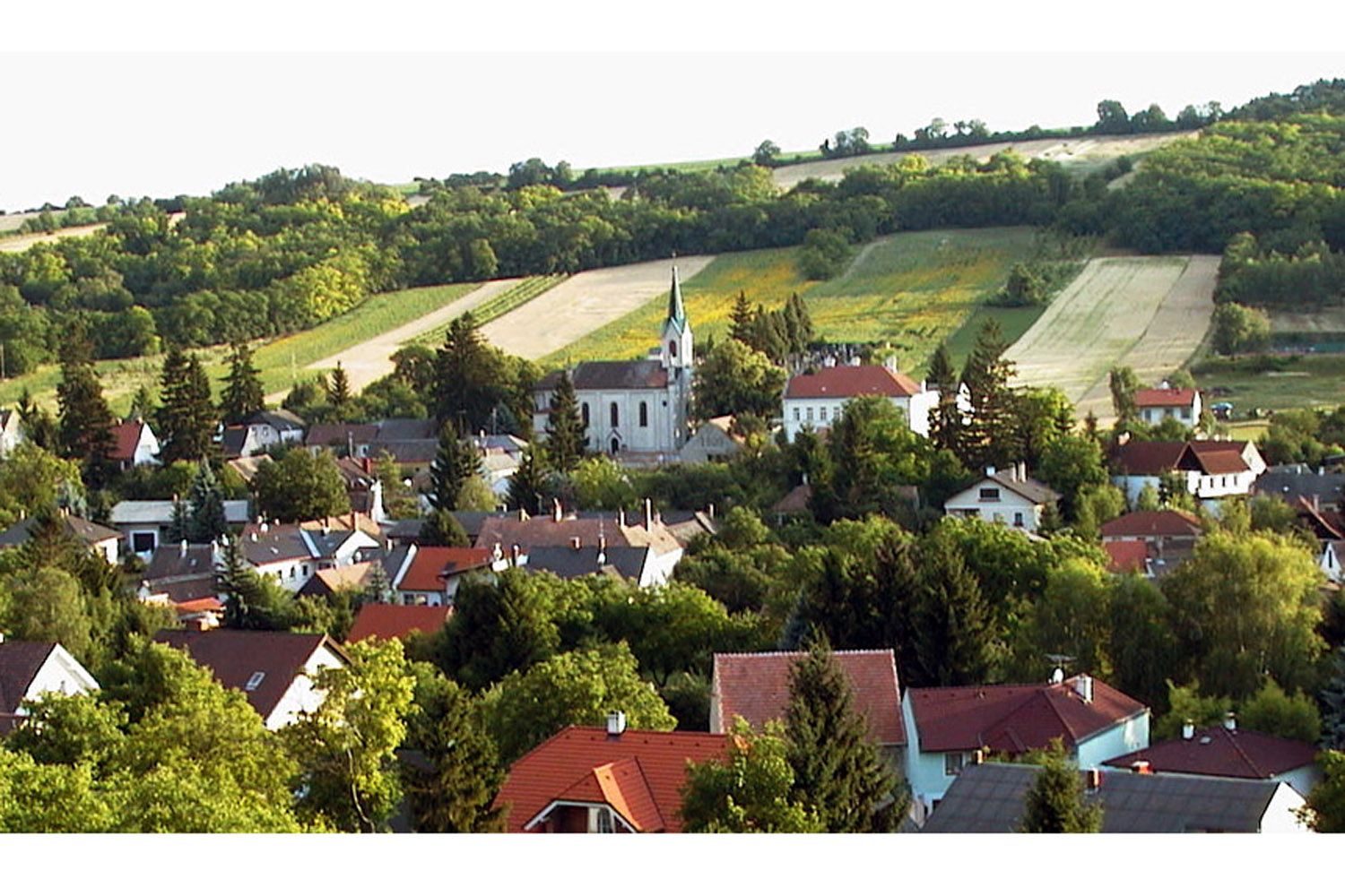 Krajina s vesnicí a kostelem v Unterolberndorfu.