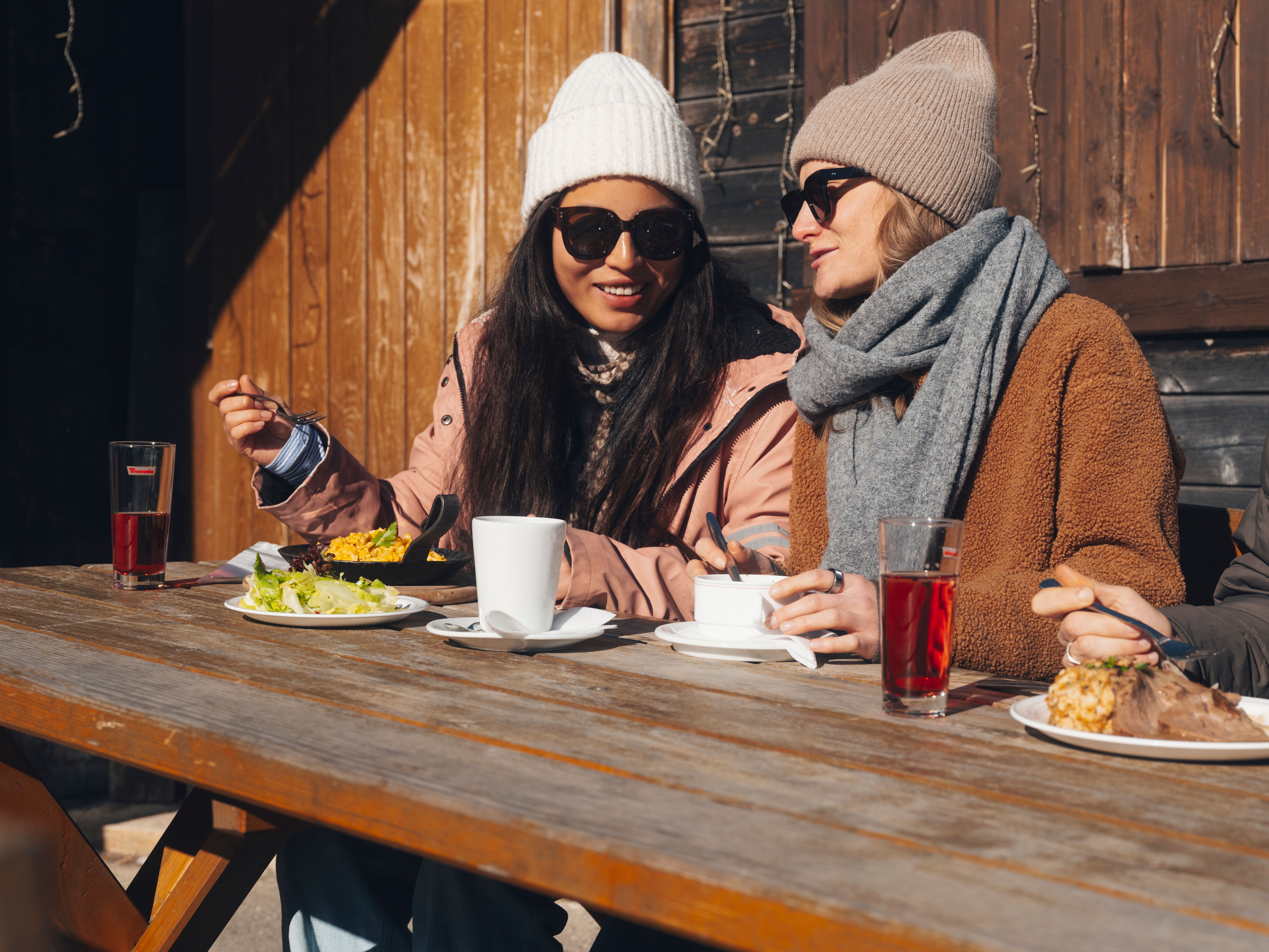 Dva běžkaři na zasněžené trase v zimní horské krajině.