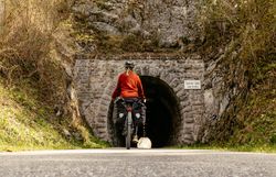Ein Radfahrer genießt die frische Bergluft und die atemberaubende Natur, während er auf dem Ybbstalradweg in die Tiefe eines alten Tunnels fährt. Umgeben von üppigem Grün und majestätischen Felsen, wird die Fahrt zu einem unvergesslichen Erlebnis in der idyllischen Landschaft des Mostviertels.