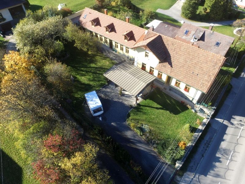Letecký pohled na dům se zahradou a rekreačními byty v zadní části.