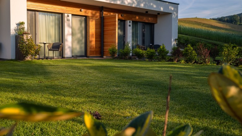 Postel ve Wies'n, © Niederösterreich Werbung / Maximilian Pawlikowsky Moderní budova s dřevěným obložením a terasou v zelené krajině.