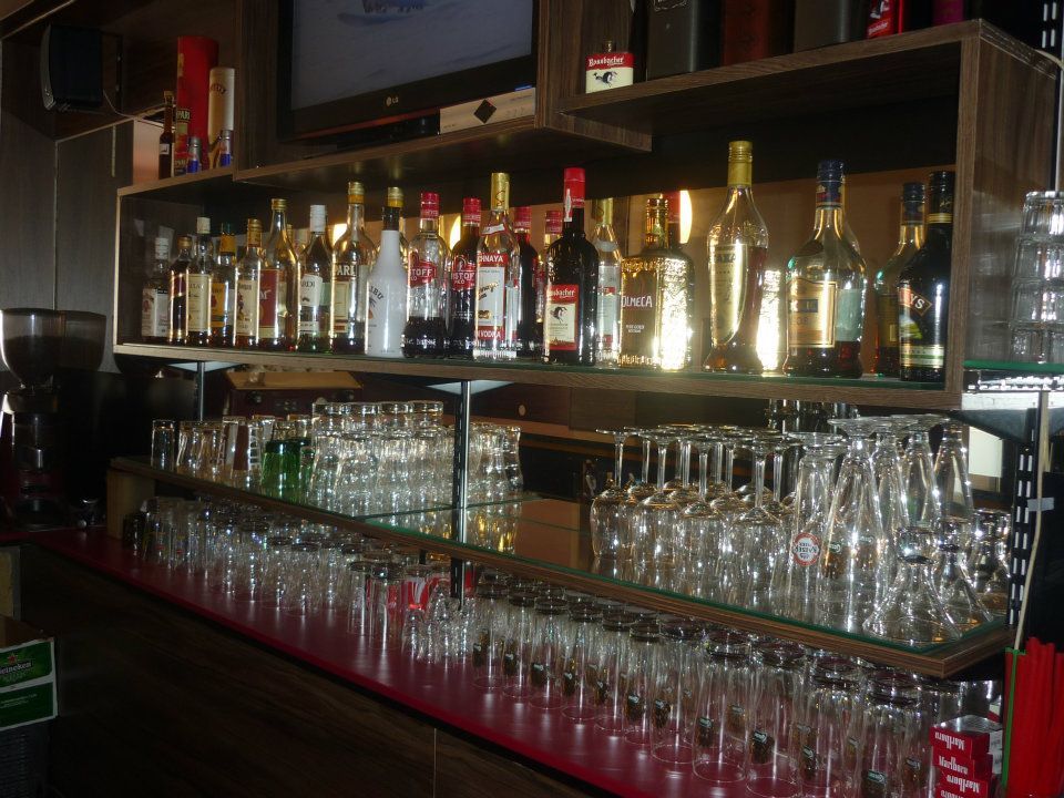 Police s lahvemi a sklenicemi v baru.