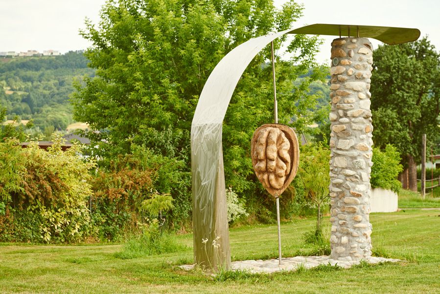 Socha ořechu v Krummnußbaum, obklopená stromy a loukou.