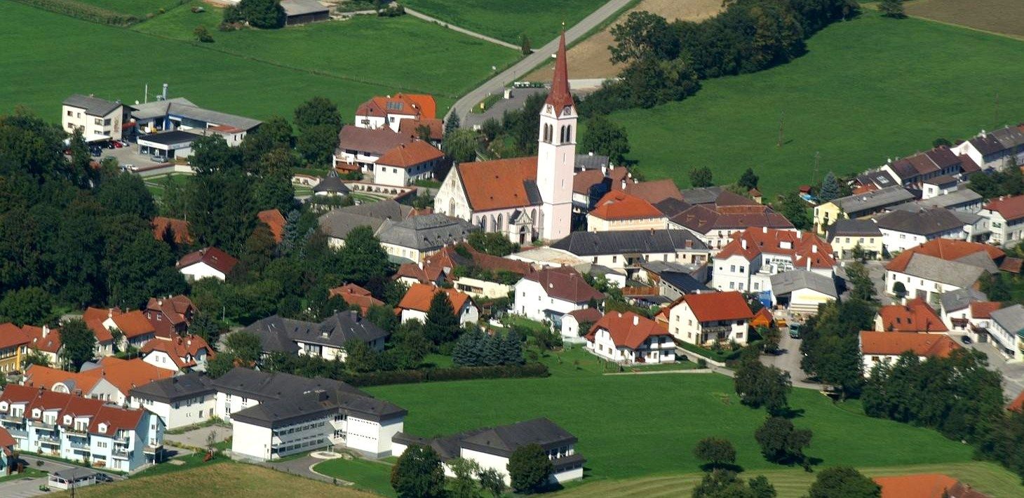 Letecký pohled na obec Weistrach s kostelem a okolními domy.
