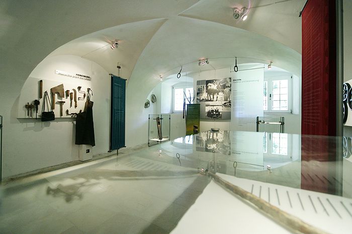 Pohled do interiéru muzea s nástroji a historickými fotografiemi.