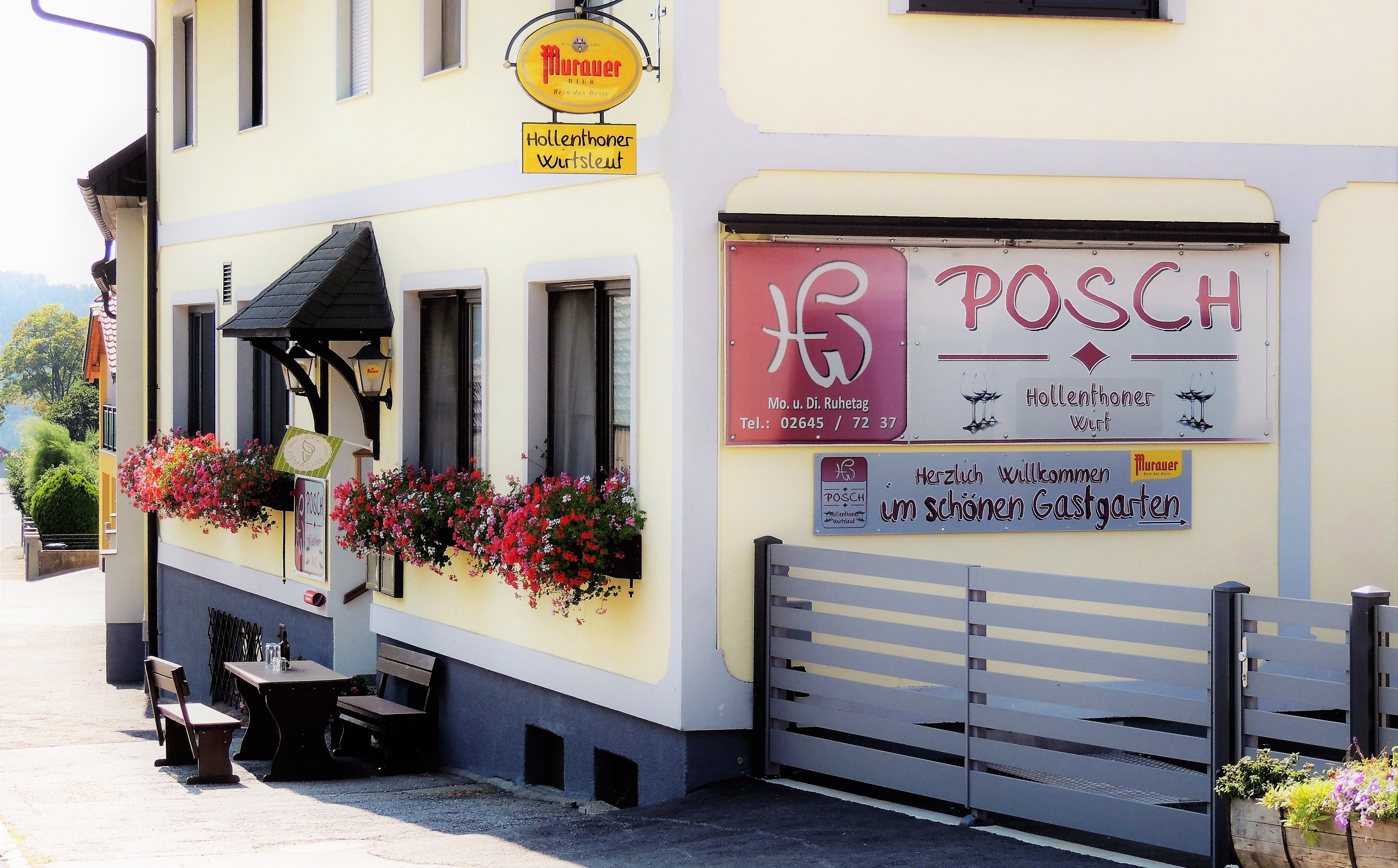 Pohled zvenčí na restauraci Gasthaus Posch s květinami a posezením.