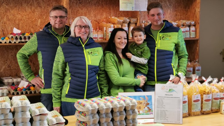 he family stands behind a counter selling eggs and pasta., © Familie List