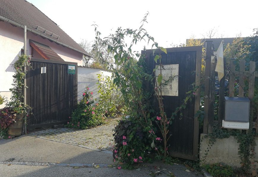 Vstupní brána do vinice s rostlinami a květinami.