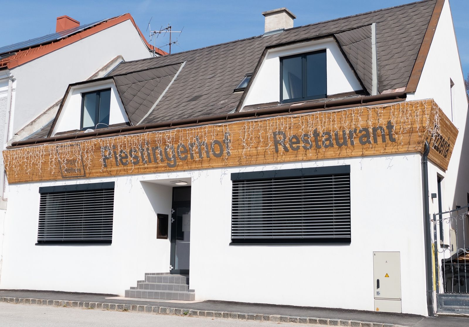 Fasáda restaurace Piestingerhof zdobená pohádkovými světýlky.
