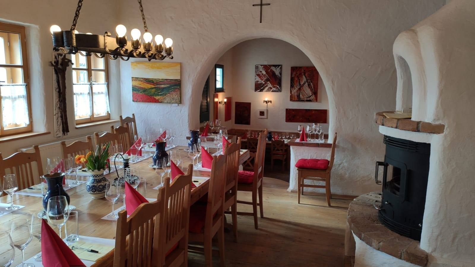 Útulný pokoj s prostřeným stolem, skleničkami na víno a krbem.