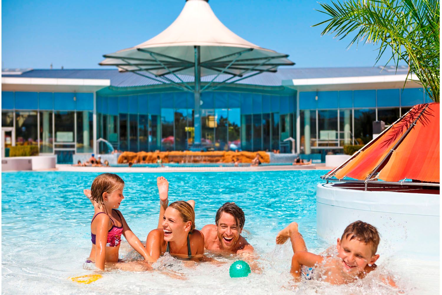 Rodina si hraje ve venkovním bazénu v hotelu Therme Laa/Thaya.