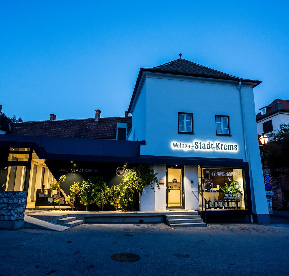 Außenansicht des beleuchteten Weinguts Stadt Krems in der Abenddämmerung. Das Weingut befindet sich in Krems an der Donau, Donau in Niederösterreich.