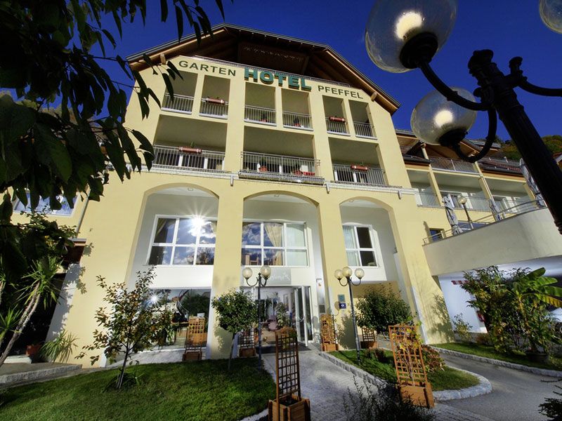 Vnější pohled na Gartenhotel Pfeffel se žlutou fasádou a balkony.