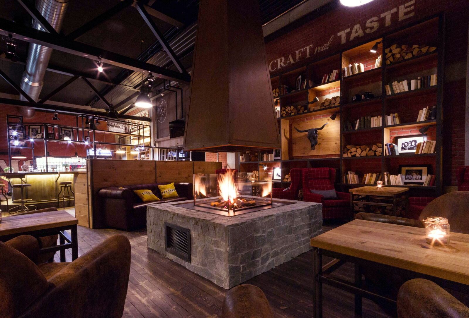 Útulný pokoj s krbem, dřevěným nábytkem a policemi na knihy.