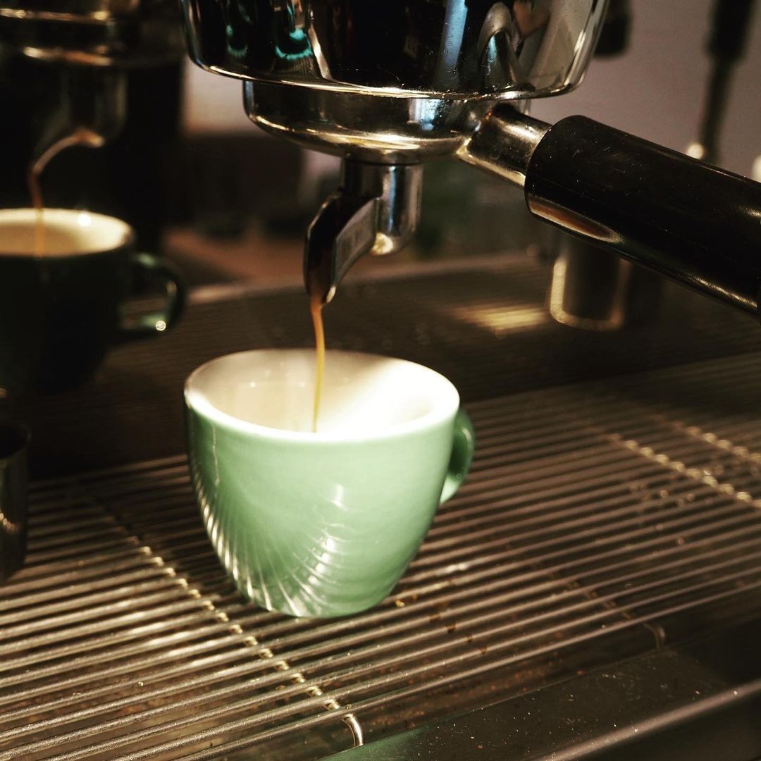 Espresso naplní zelený šálek kávou.