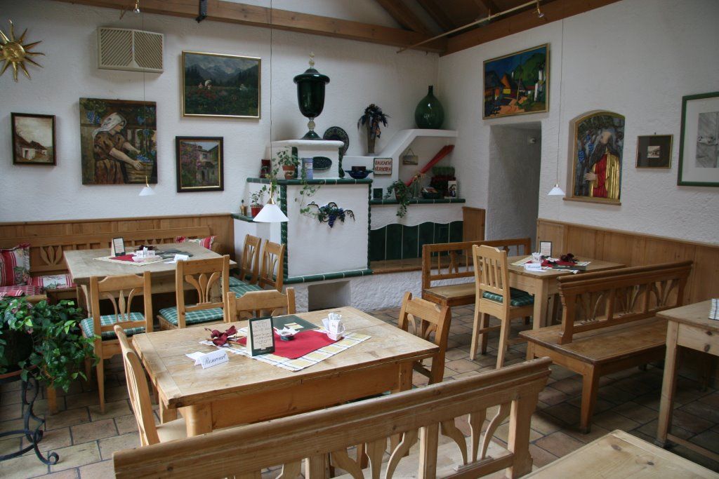 Útulná jídelna s dřevěným nábytkem a dekorativními obrazy na stěnách.