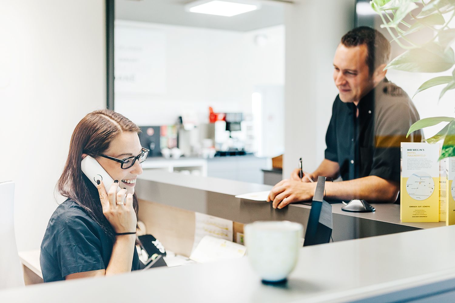 Recepční telefonuje s hostem na recepci.